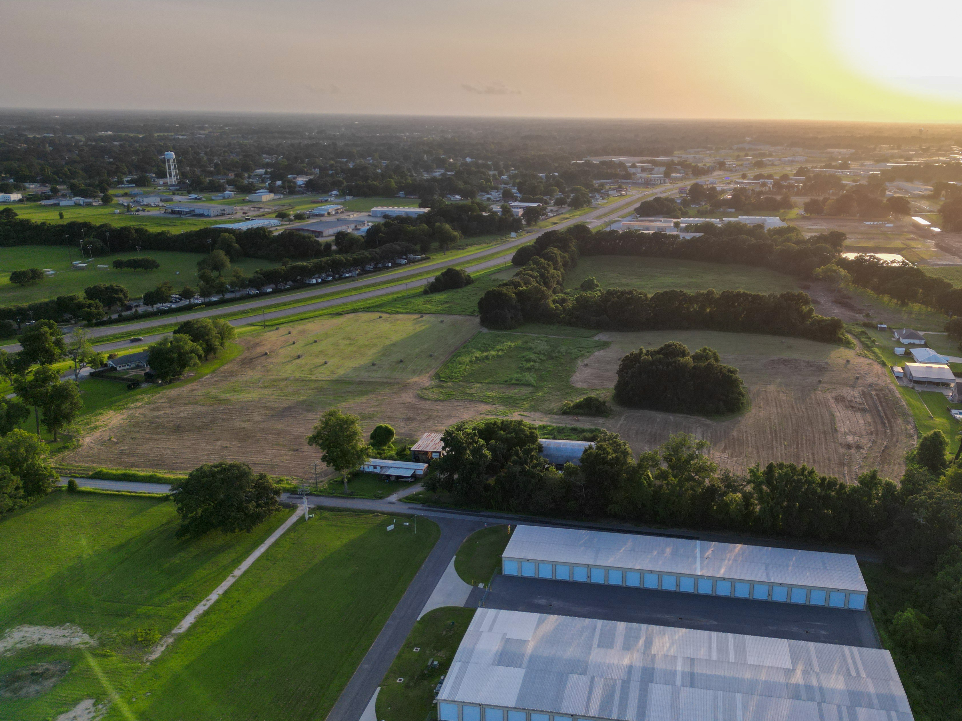 Wide drone view showing the property's proximity to highway and city